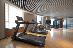 A gym with treadmills, exercise bikes, and a weight machine.