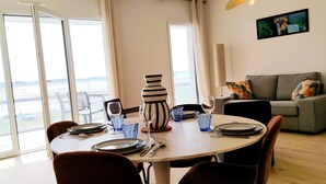 Un comedor con una mesa redonda, sillas y un florero.