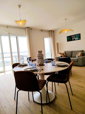 A dining area with a round table, chairs, and a vase.