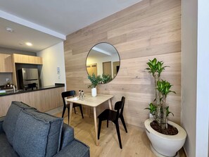 A modern kitchen with a built-in fridge and a dining area with a wooden wall and a round mirror. - w Upscale Loft w Balcony in Roma Norte (Mexico City)