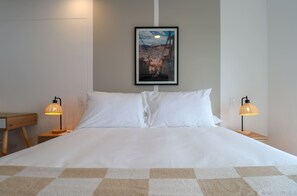 A neatly made bed with white linens, two bedside lamps, a framed picture on the wall, and a checkered throw on the bed. - w Upscale 2BR w Balcony View in Miraflores (Lima)