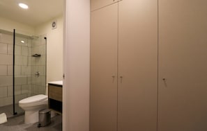 Ein Badezimmer mit Toilette, Dusche, Waschbecken und einem Schrank.