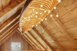 A wooden ceiling with a curved design and hanging light fixtures. - Stunning views of Lake Charlevoix (Charlevoix)