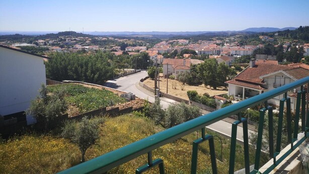 A residential area with houses, a road, and a clear sky.