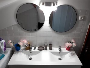 Une salle de bain avec deux lavabos, un miroir et des toilettes.