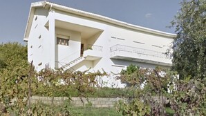 A white building with a balcony and a staircase.