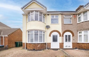 A row of terraced houses with a corner bay window, a satellite dish, and a brick facade.