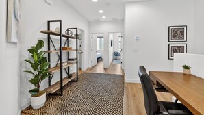 A modern interior with a wooden dining table, a patterned rug, a bookshelf, and a potted plant. - Copper Sky Townhome - Pool & Gym (Phoenix)