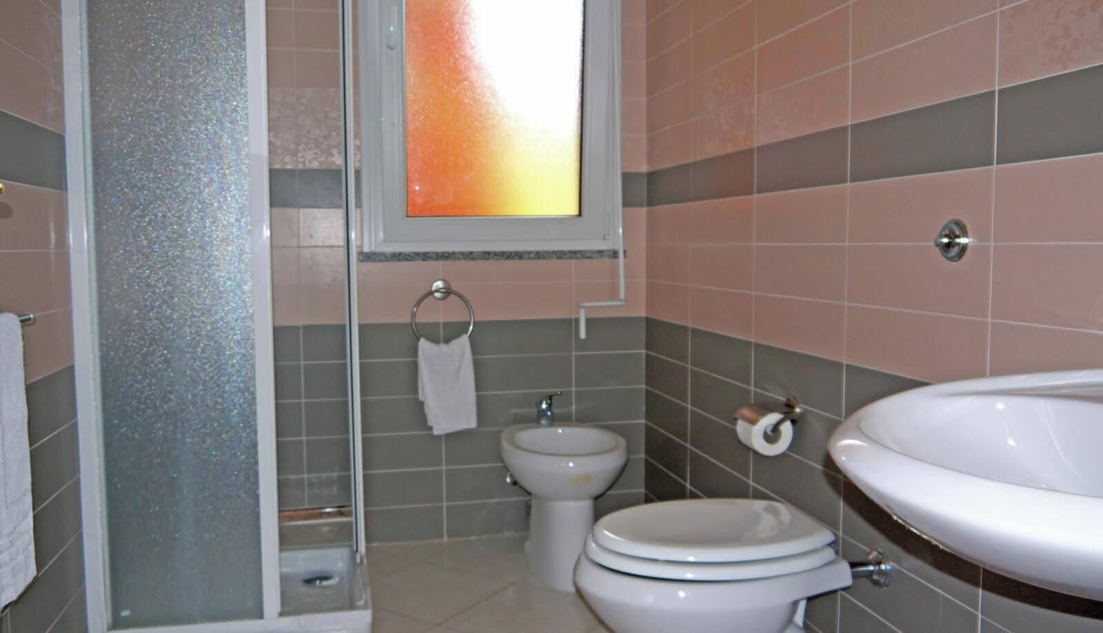 A bathroom with a toilet, bidet, and sink.