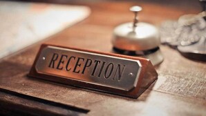 Un mostrador de recepción con un letrero que dice 'RECEPTION' sobre una superficie de madera.