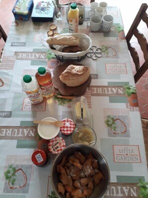 A table with food items, a basket of bread, and condiments. - les 3 notes de mérotte (Coutras)