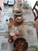 Una mesa con comida, un cesto de pan y salsas.
