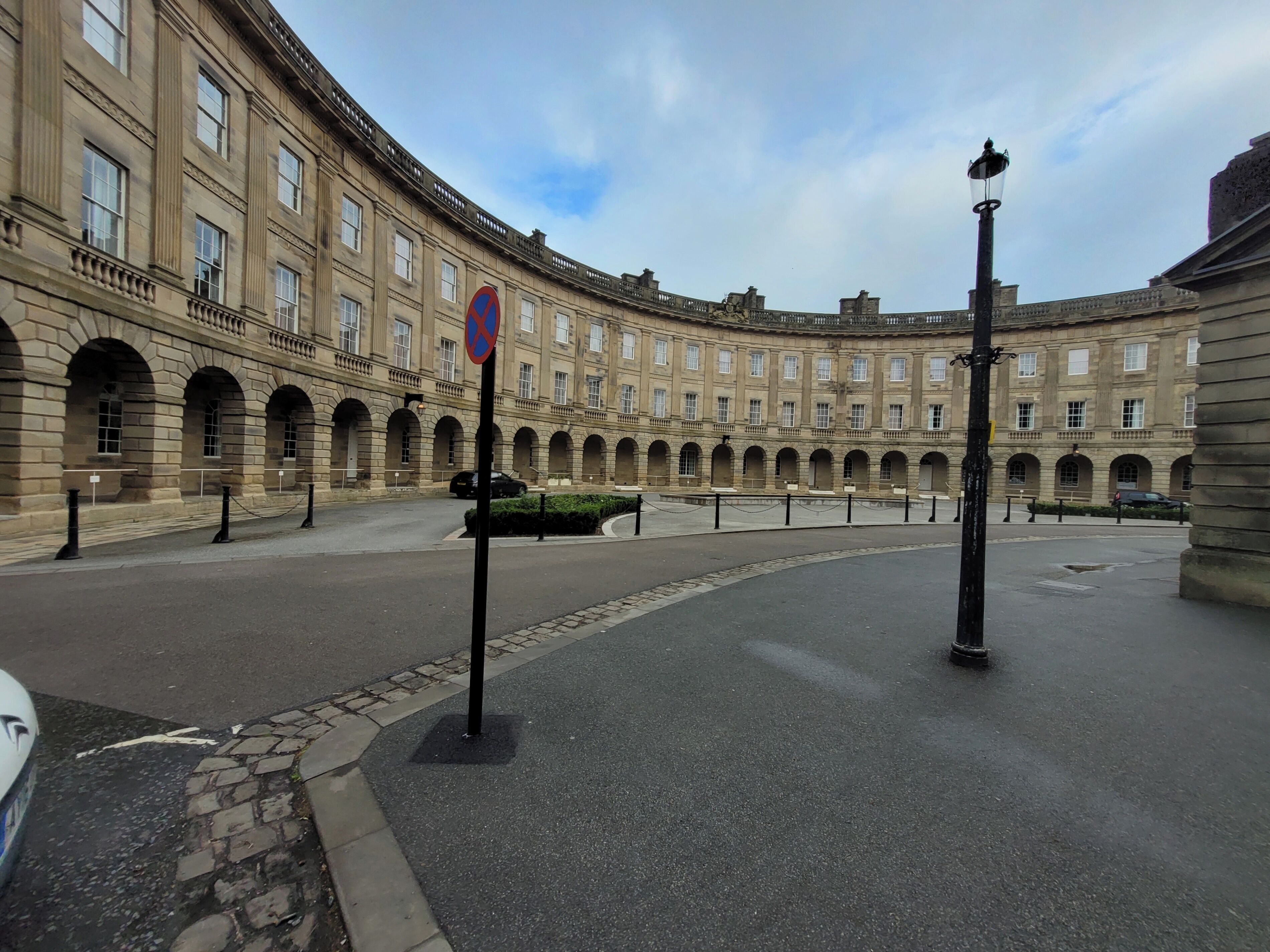 A historic building with a curved facade, arched windows, and a central courtyard.