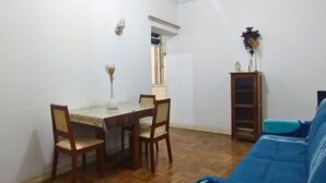 Una habitación con una mesa de comedor, sillas, un sofá, un armario y una ventana.