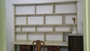 Una habitación con escritorio, silla y estantería.