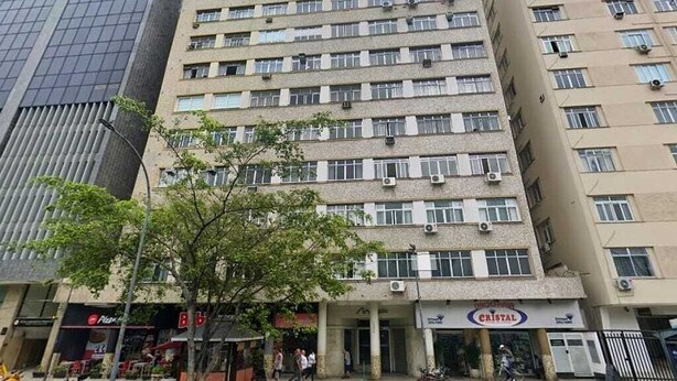 Un edificio de varios pisos con una planta baja comercial que alberga diversas tiendas.