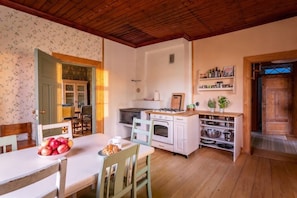 Une cuisine chaleureuse avec des meubles en bois, un poêle et un coin repas avec une table mise pour deux personnes.