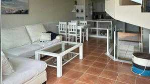 Una sala de estar moderna con sofá, mesa de centro y comedor.