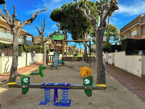 Ein Spielplatz mit Schaukeln, Rutschen und Klettergerüsten.