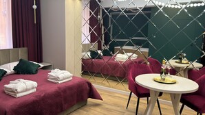 Ein Hotelzimmer mit Bett, Spiegel, Tisch mit Stühlen und einer Minibar.