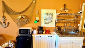 A compact kitchen with a microwave, coffee maker, and sink. - Captain’s Quarters- charming studio apartment in the countryside (Berlin Center)