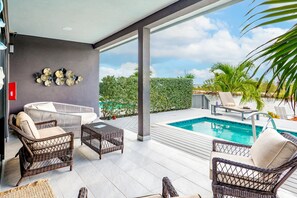 Ein moderner Poolbereich im Freien mit Korbmöbeln, einem Whirlpool und Blick auf das Meer.