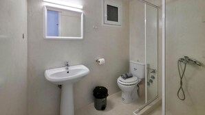 A bathroom with a pedestal sink, toilet, and a glass-enclosed shower. - HOTEL GALINI  (Katerini)