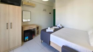 A bedroom with a bed, a desk, a mirror, a wardrobe, and a television. - HOTEL GALINI  (Katerini)