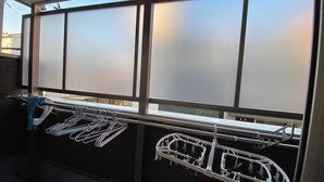 Una habitación con ventana, un perchero de metal y un tendedero de pared.