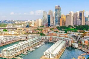 A cityscape with modern skyscrapers, a marina with docked boats, and a mix of residential and commercial buildings. - Renovated Warehouse Conversion In Heart Of Sydney! (Dawes Point)