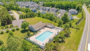 An aerial view of a residential area with houses, a swimming pool, and a road. - Saltwater Heaven (Rehoboth Beach)