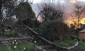 A stone staircase leading up to a house, surrounded by greenery and trees. - The River House - Merrijig (Merrijig)