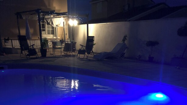 A swimming pool with a blue light feature and a ring float. - Maison Vallée: Swimming Pool / Groupama Stadium / Euroexpo / LDLC ARENA / Access to Downtown (Décines-Charpieu)