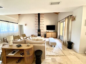 Ein modernes Wohnzimmer mit einer Couch, einem Couchtisch, einem Fernseher und einem Kamin.