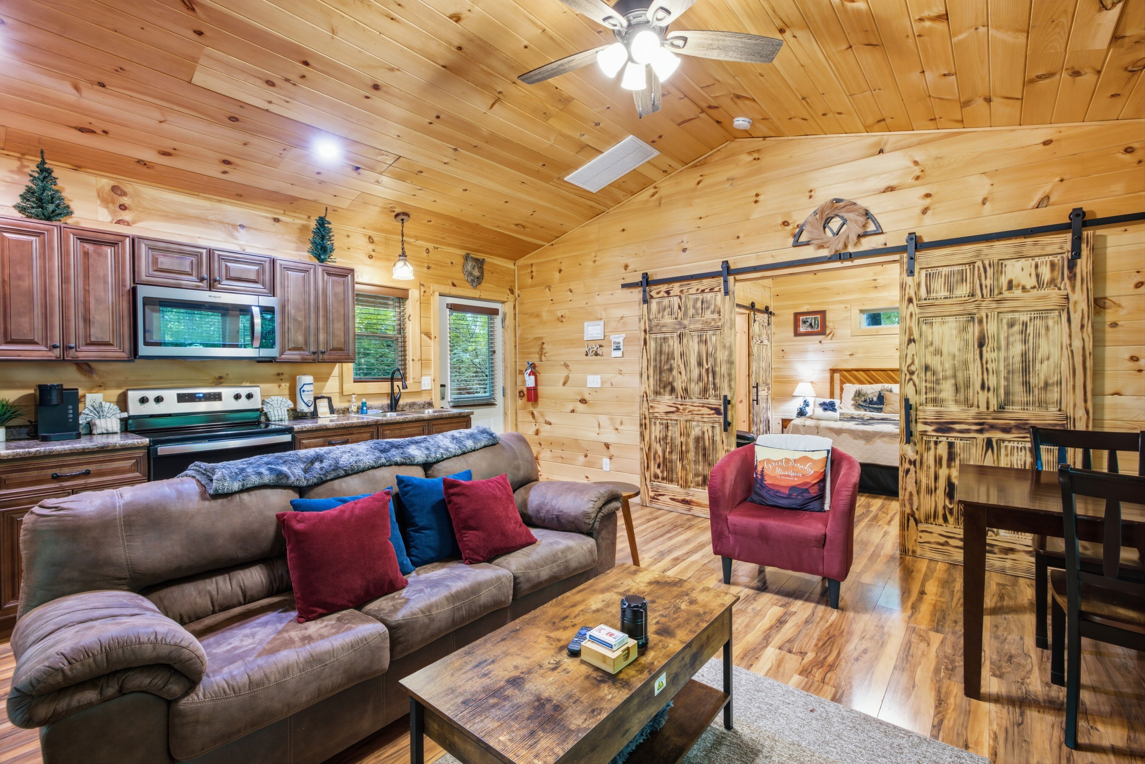A wooden interior with a sofa, coffee table, and dining area.