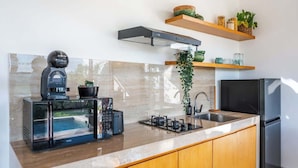 A modern kitchen with a built-in coffee machine, a gas stove, and a refrigerator. - Villa w/ Pool, Rice Field & Mountain Views (Pererenan)