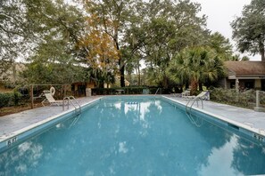 A rectangular swimming pool with a 8 ft depth marker, surrounded by trees and a small building. - Sunset Rentals | Queens Grant 671 | Dog Friendly (Hilton Head Island)