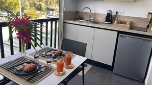 A dining area with a table set for breakfast, a kitchen with a microwave, and a dishwasher.