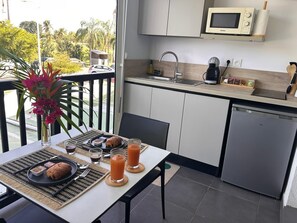 Un coin repas avec une table mise pour le petit-déjeuner, une cuisine équipée d’un four à micro-ondes et d’un lave-vaisselle.