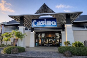 Um edifício de cassino com um letreiro grande escrito 'Casino', janelas amplas e um design arquitetônico moderno.