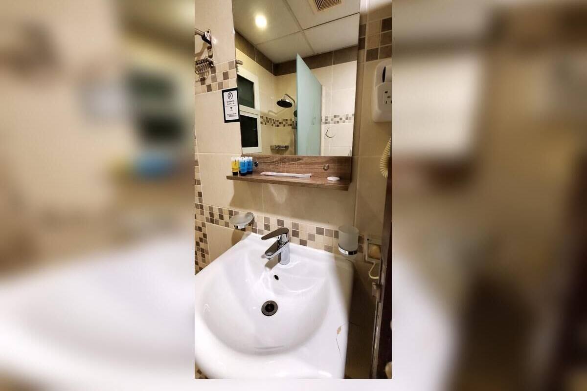 Un baño con lavamanos blanco, un espejo y una ducha.