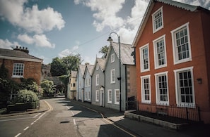 A quiet street lined with traditional buildings, a clear sky, and a no-entry sign.