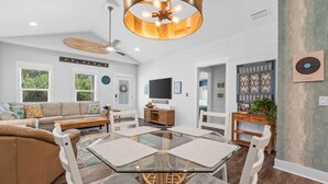Un salon spacieux avec une table basse en verre, un canapé et un ventilateur de plafond.