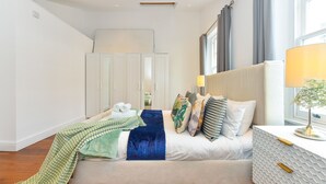 A modern bedroom with a bed, bedside table, lamp, and wardrobe. - Knightsbridge Beauchamp Exclusive II - 46bp (London)
