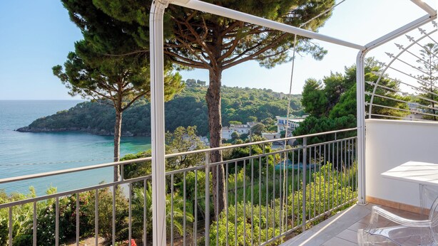 A balcony with a clear view of the sea and a tree. - Lilium Gaeta Apartment by Mamo Florence (Gaeta)