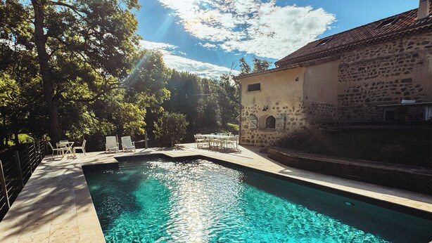 A swimming pool with clear water, surrounded by a wooden deck and stone walls. - Ardèche estate from 1748 - Private heated pool - 16 travelers (Saint-Barthélemy-Grozon)