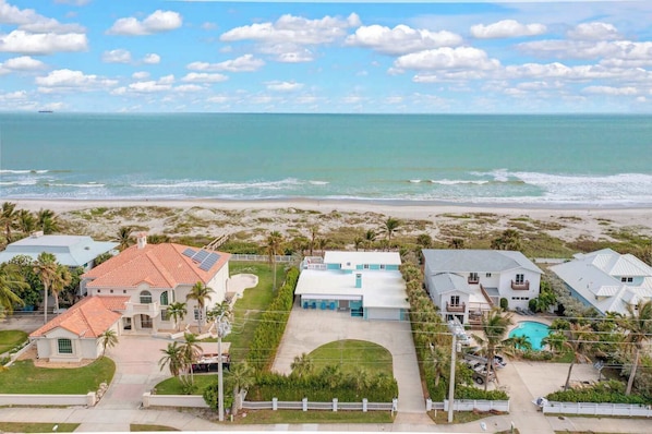A coastal residential area with houses, a swimming pool, and a beach view.