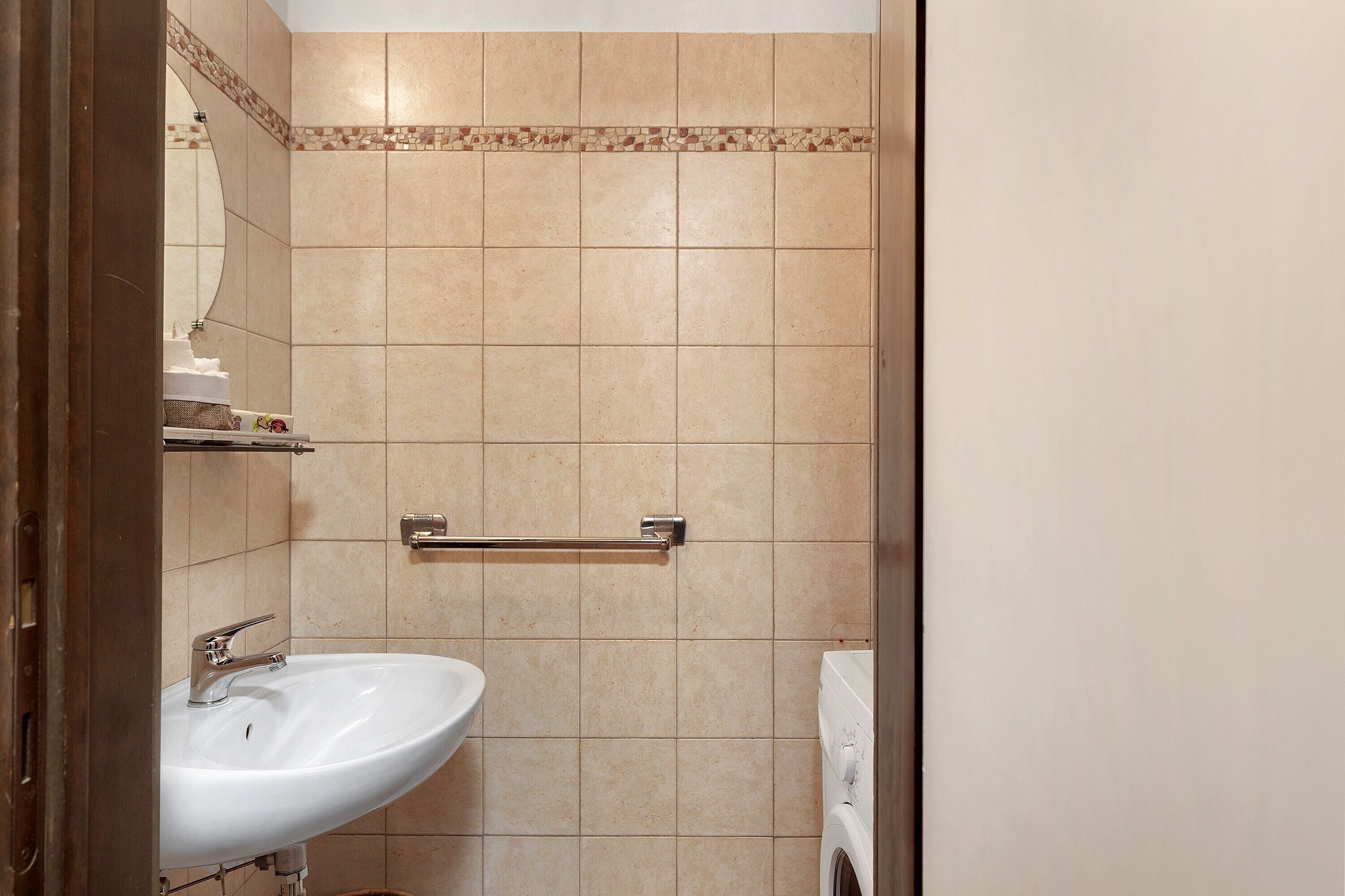 Ein Badezimmer mit einem weißen Waschbecken, einem Handtuchhalter und einer Toilette.