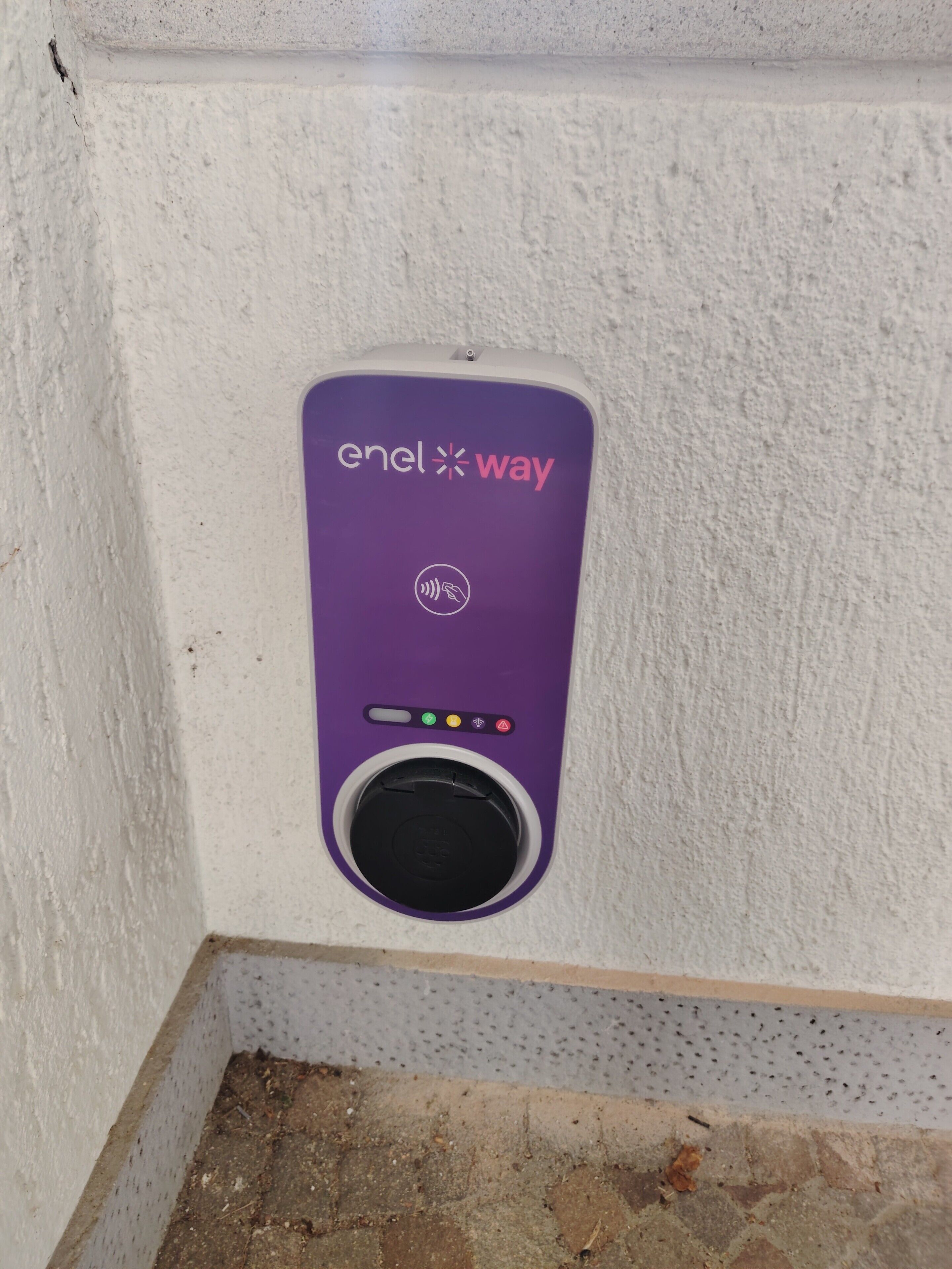 Eine violette Enel Way Ladestation an einer strukturierten weißen Wand.