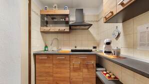 Eine Küche mit Holzausstattung, einer Edelstahlspüle und einer Kaffeemaschine.